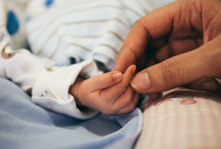 person holding baby's index finger